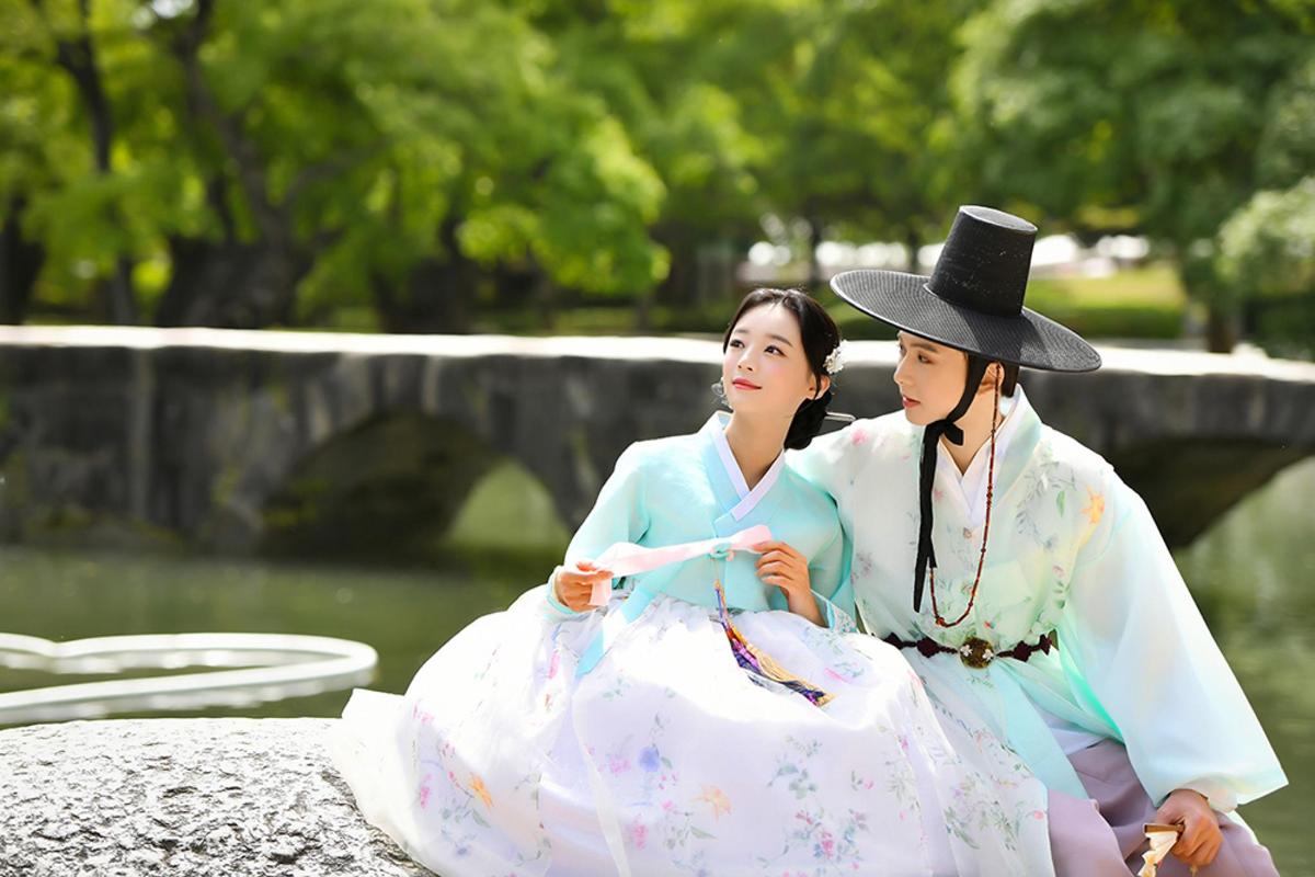two women sitting on a rock in a park