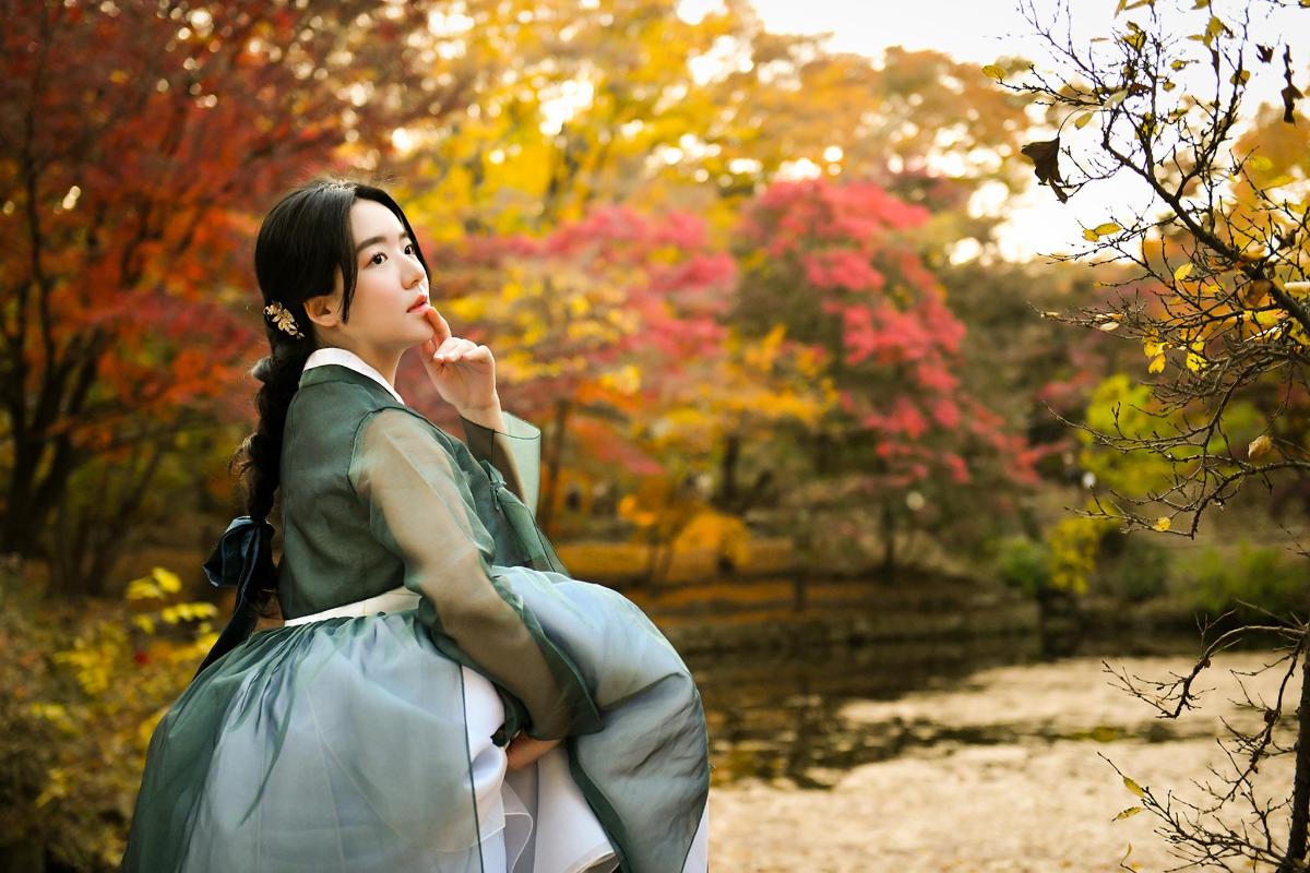 a woman is standing in a park