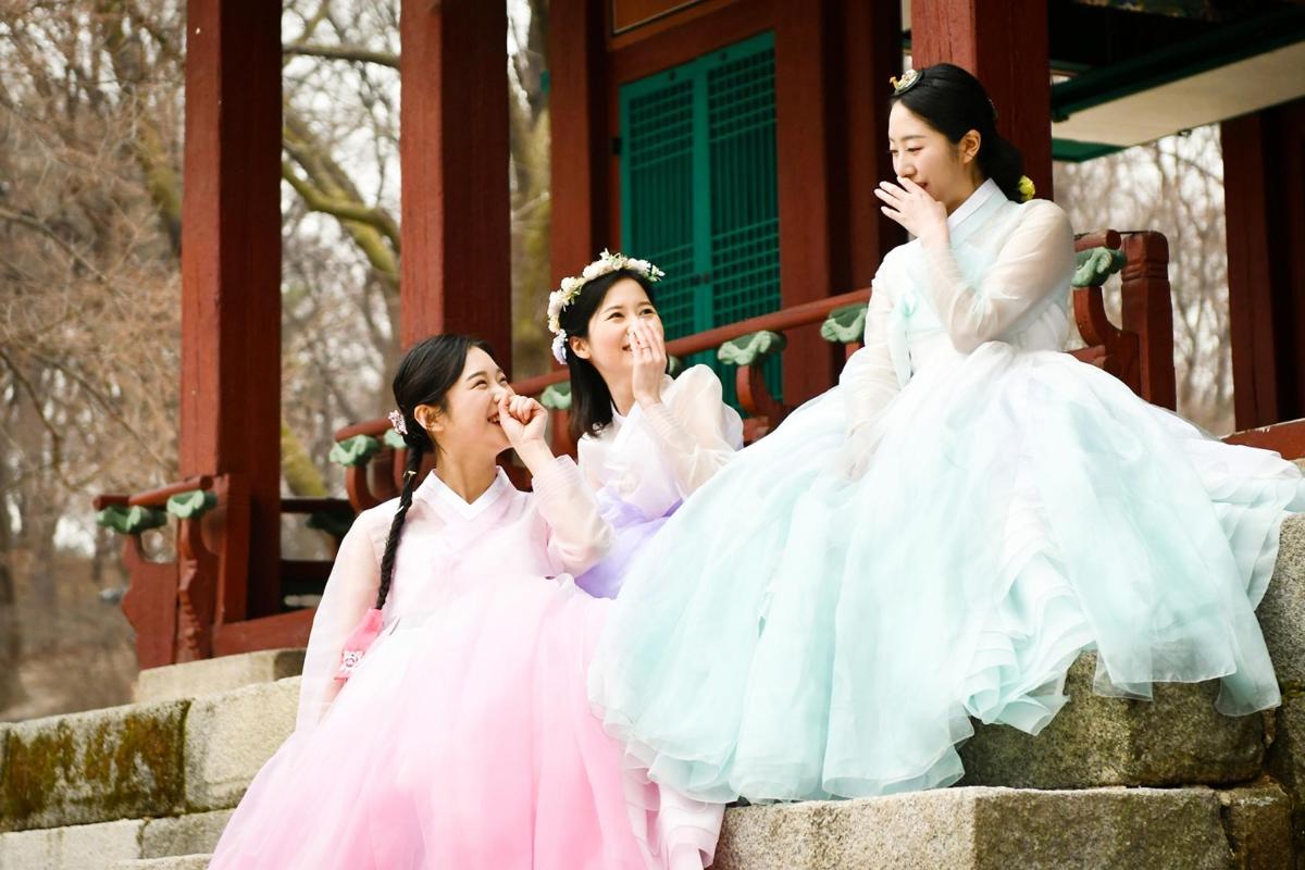 three women in wedding dresses sitting on steps