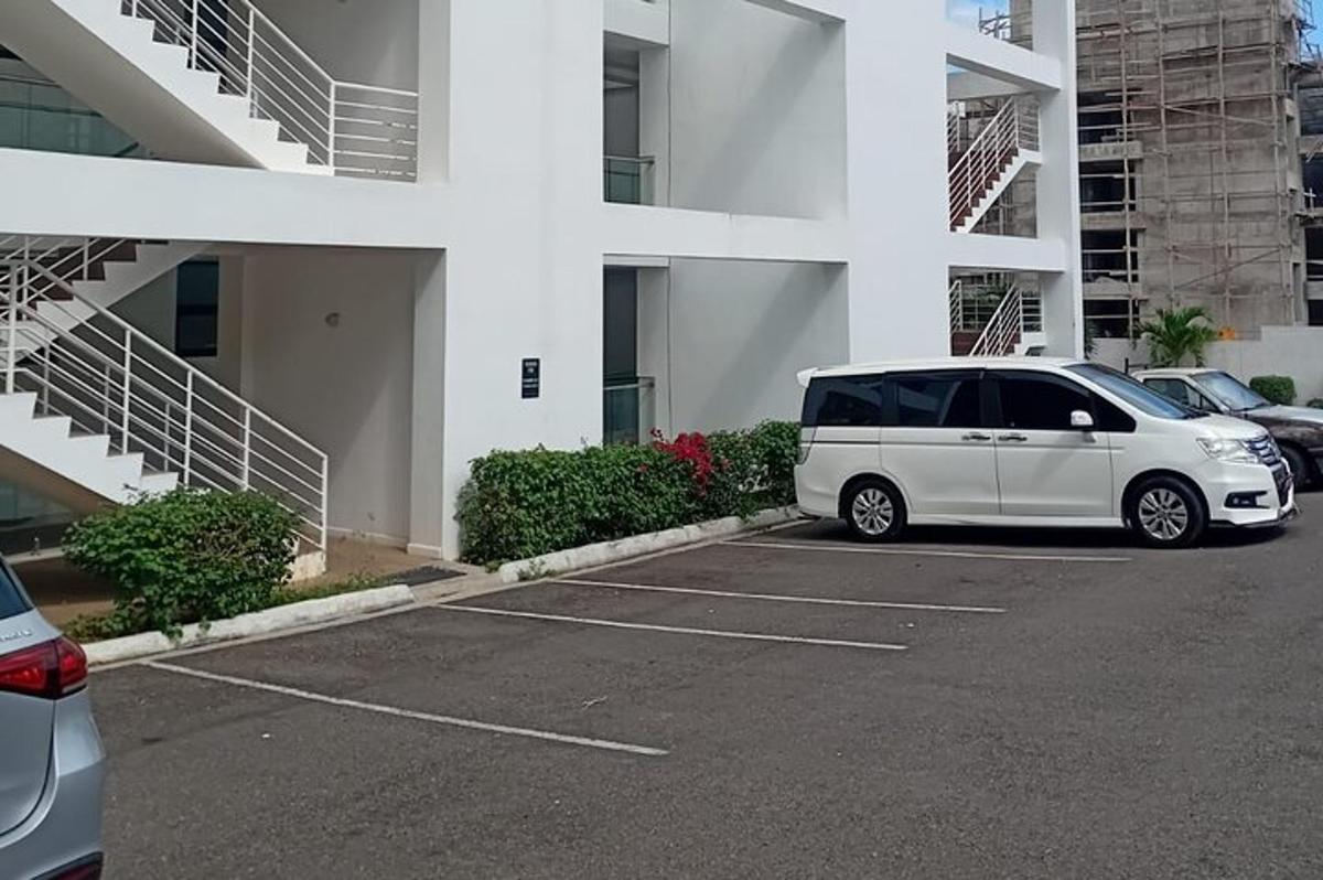en hvit varebil parkert på en parkeringsplass foran en bygning