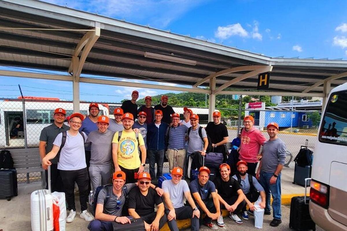 en gruppe mennesker poserer for et bilde på en bensinstasjon