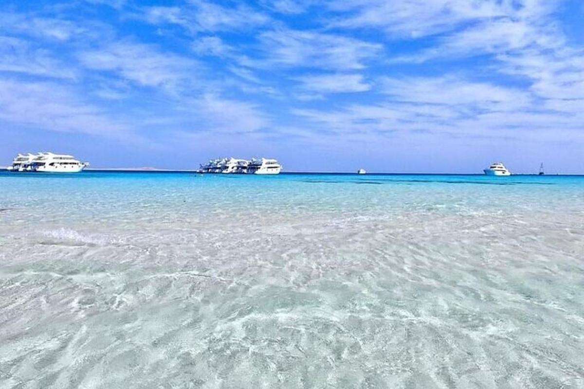 uma vista do oceano com três barcos na água