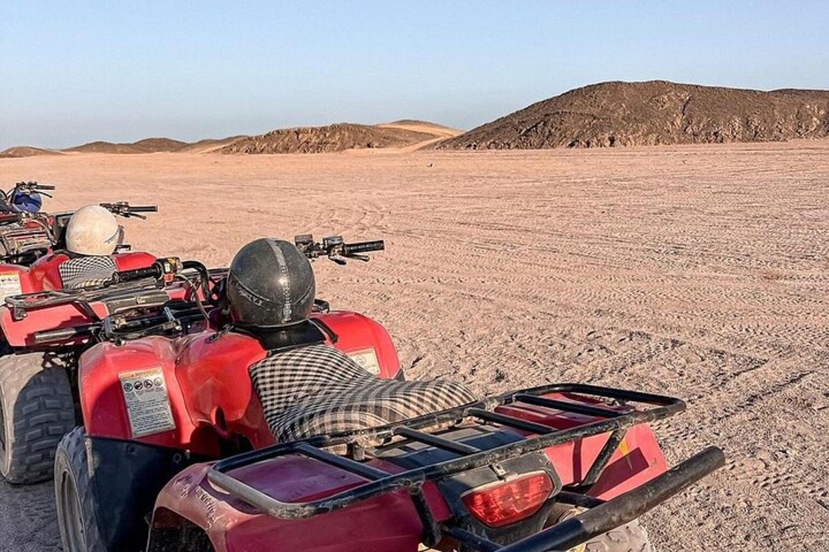 uma pessoa andando de quadriciclo no deserto
