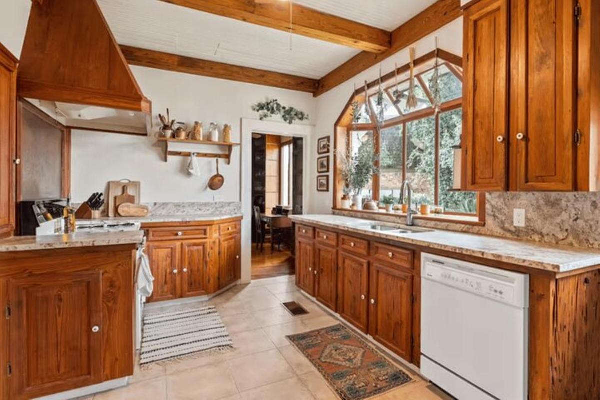 a kitchen with wooden cabinets and a white dishwasher