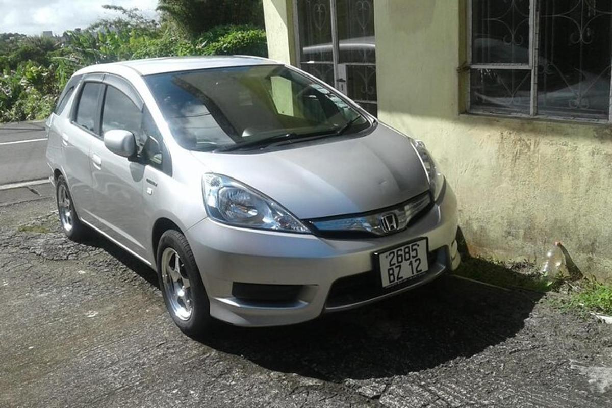 sebuah kereta kecil berwarna perak diletakkan di sebelah sebuah bangunan
