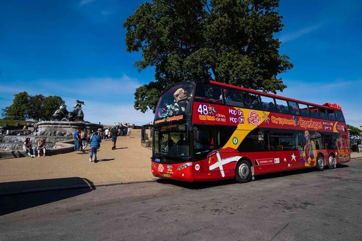 punane kahekordne buss sõidab mööda tänavat