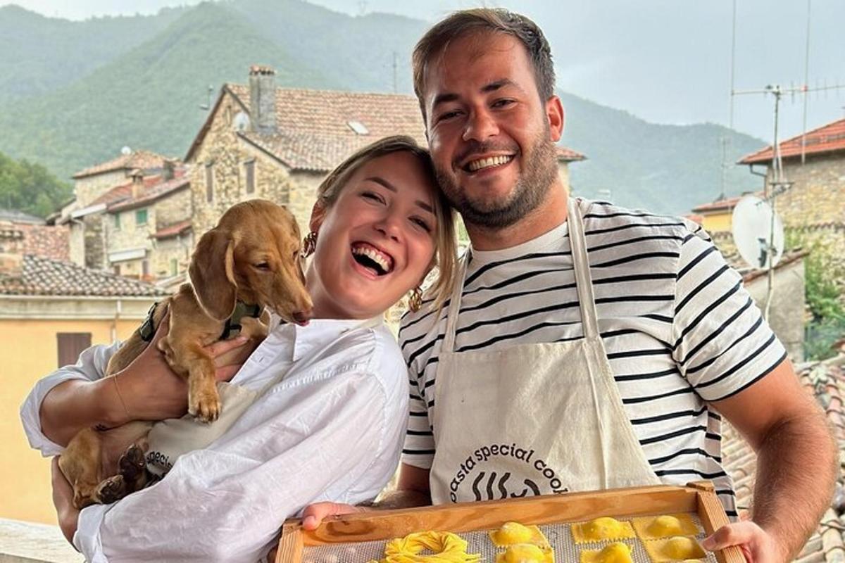 um homem e uma mulher segurando um cachorro em uma caixa