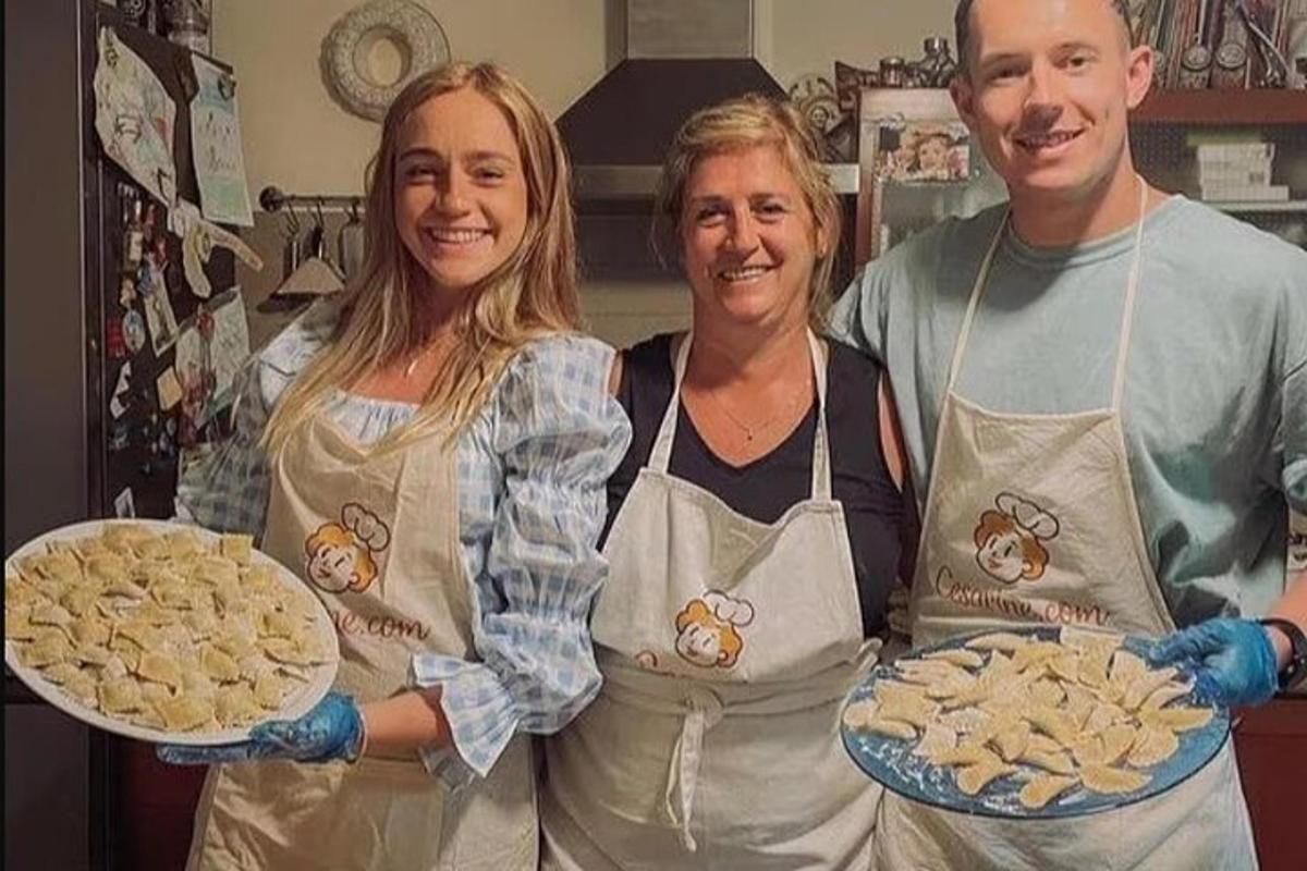 two women and a man holding two plates of food