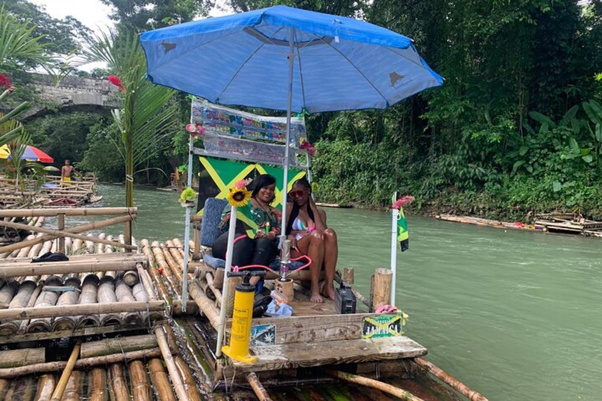 hai người phụ nữ ngồi trên bè với một chiếc ô