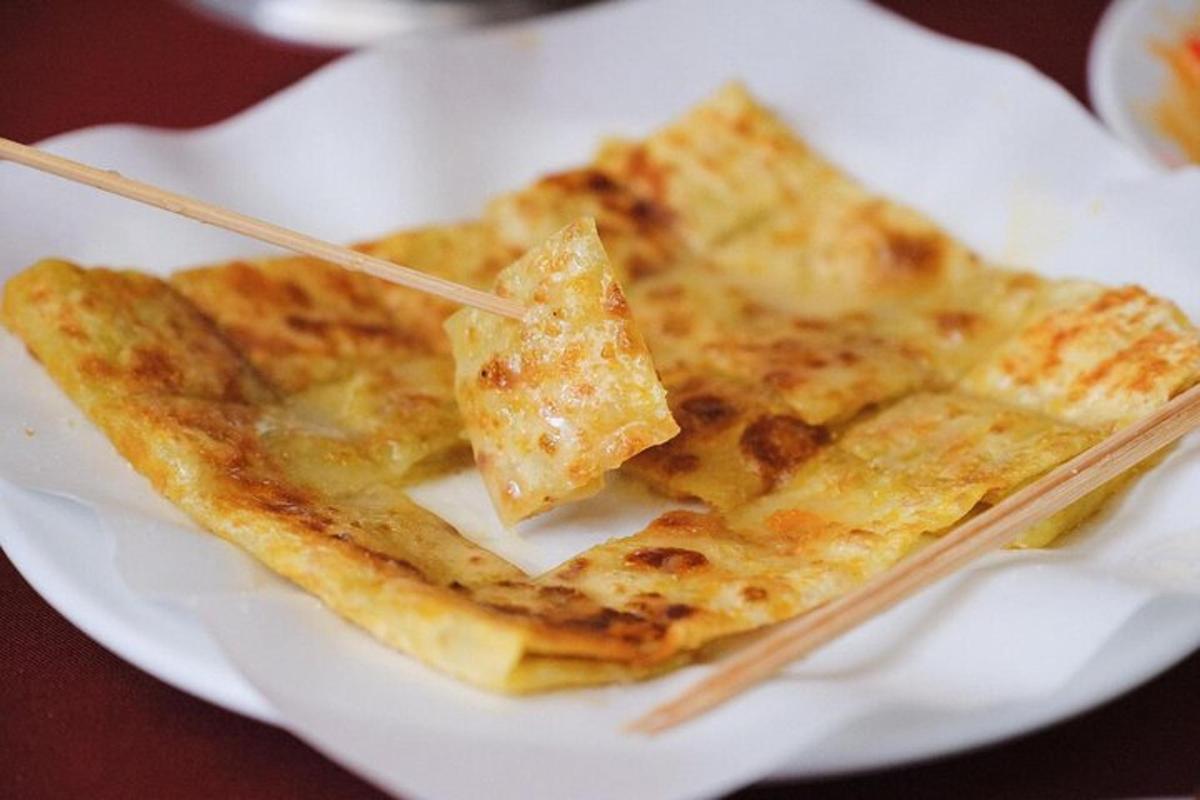 um prato branco de comida com pauzinhos dentro