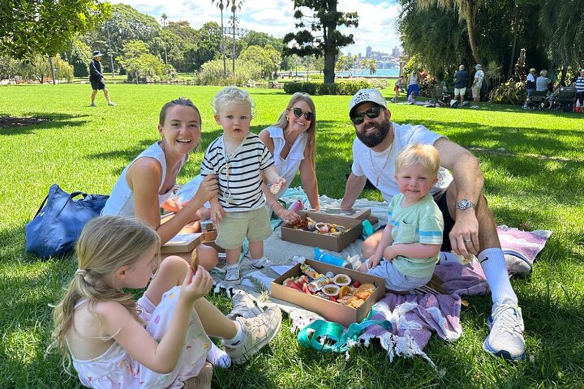 una familia sentada en el césped de un parque