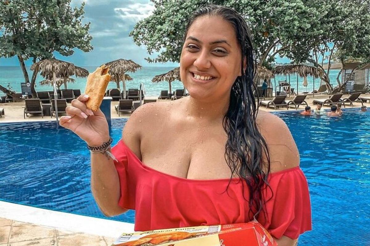 uma mulher de vestido vermelho segurando um pedaço de comida