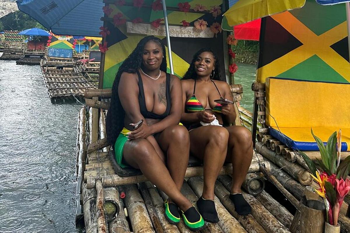 duas mulheres em trajes de banho sentadas sob um guarda-chuva