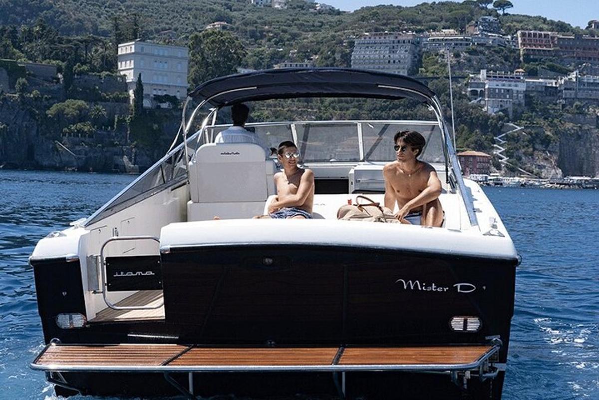 two boys sitting on a boat in the water