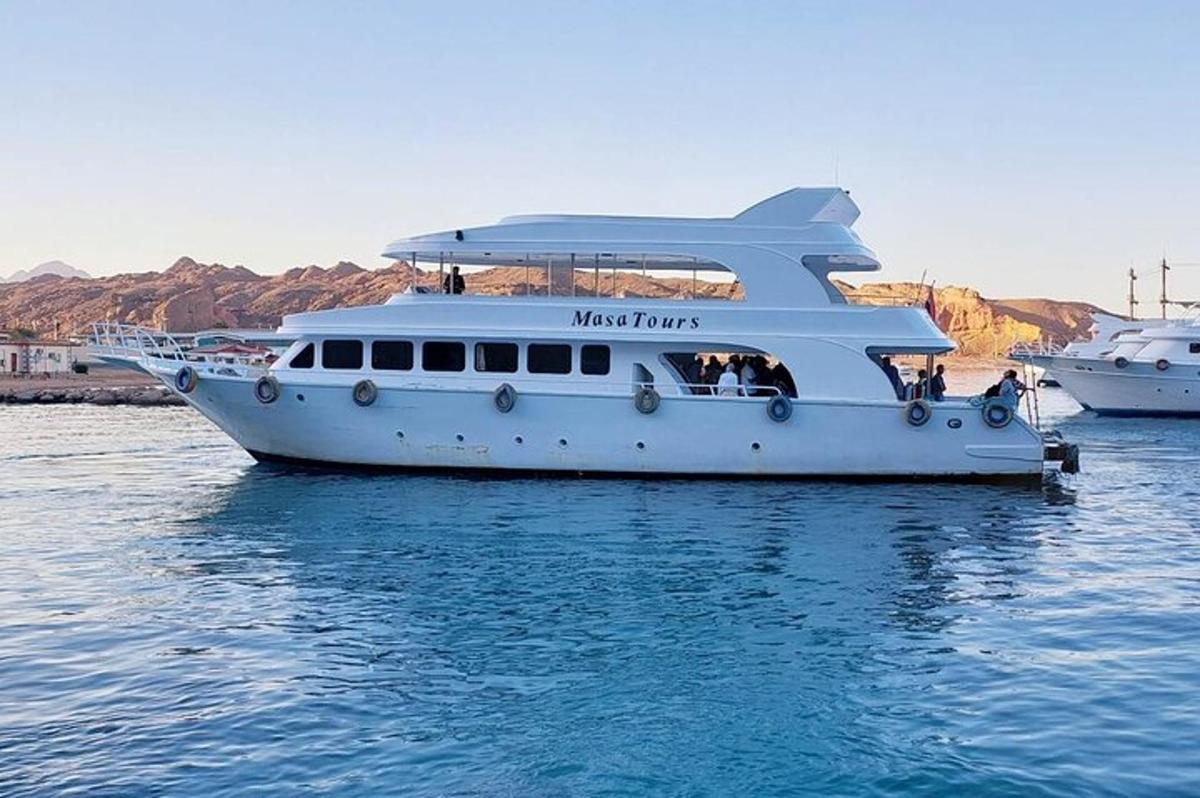 Un barco blanco en el agua con gente en él.