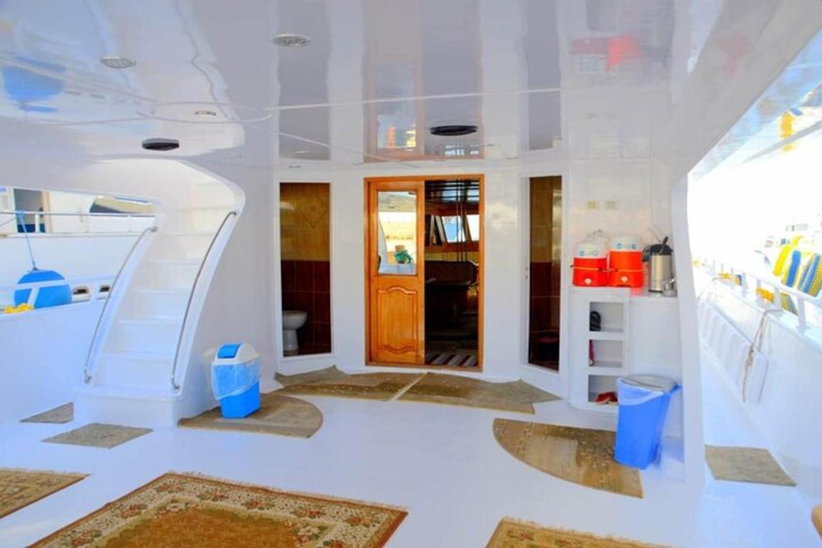 Una habitación blanca con una escalera y una puerta.