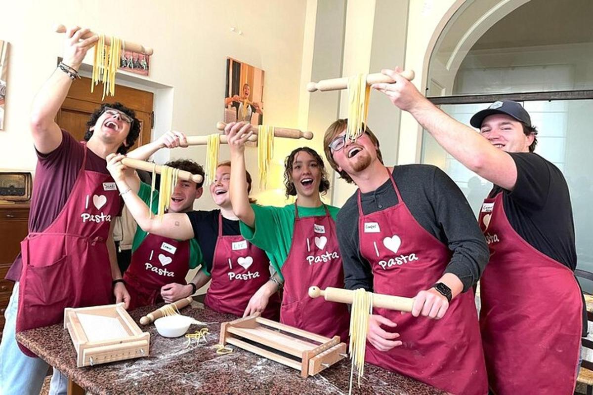 un grup de persones a la cuina sostenint pals de fusta