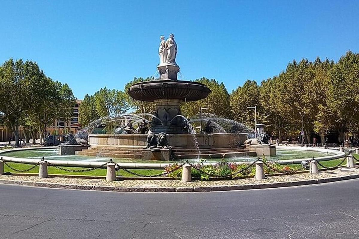 una fuente con una estatua en medio de un parque