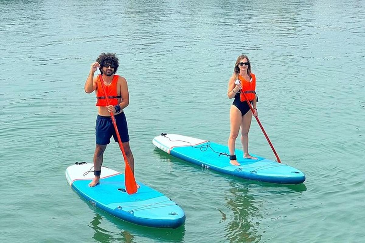 twee mensen staan op paddleboards in het water