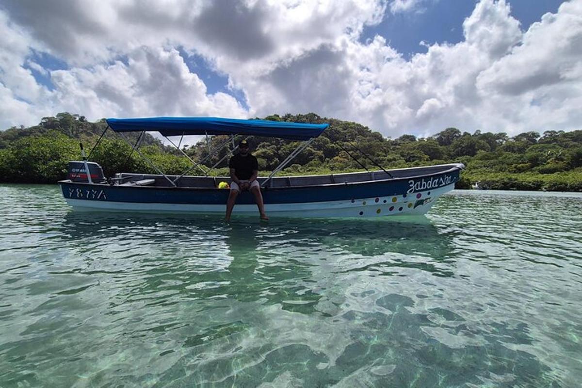 Un hombre está sentado en un bote en el agua.