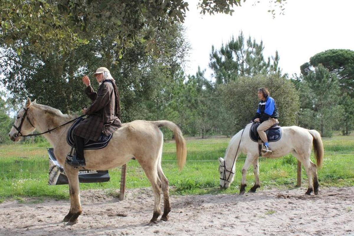dues persones munten a cavall en un camp