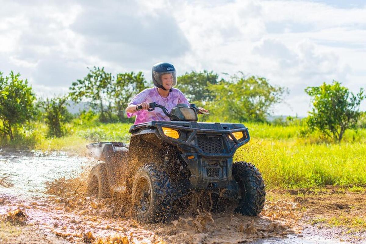 a person riding a four wheeler through a muddy field