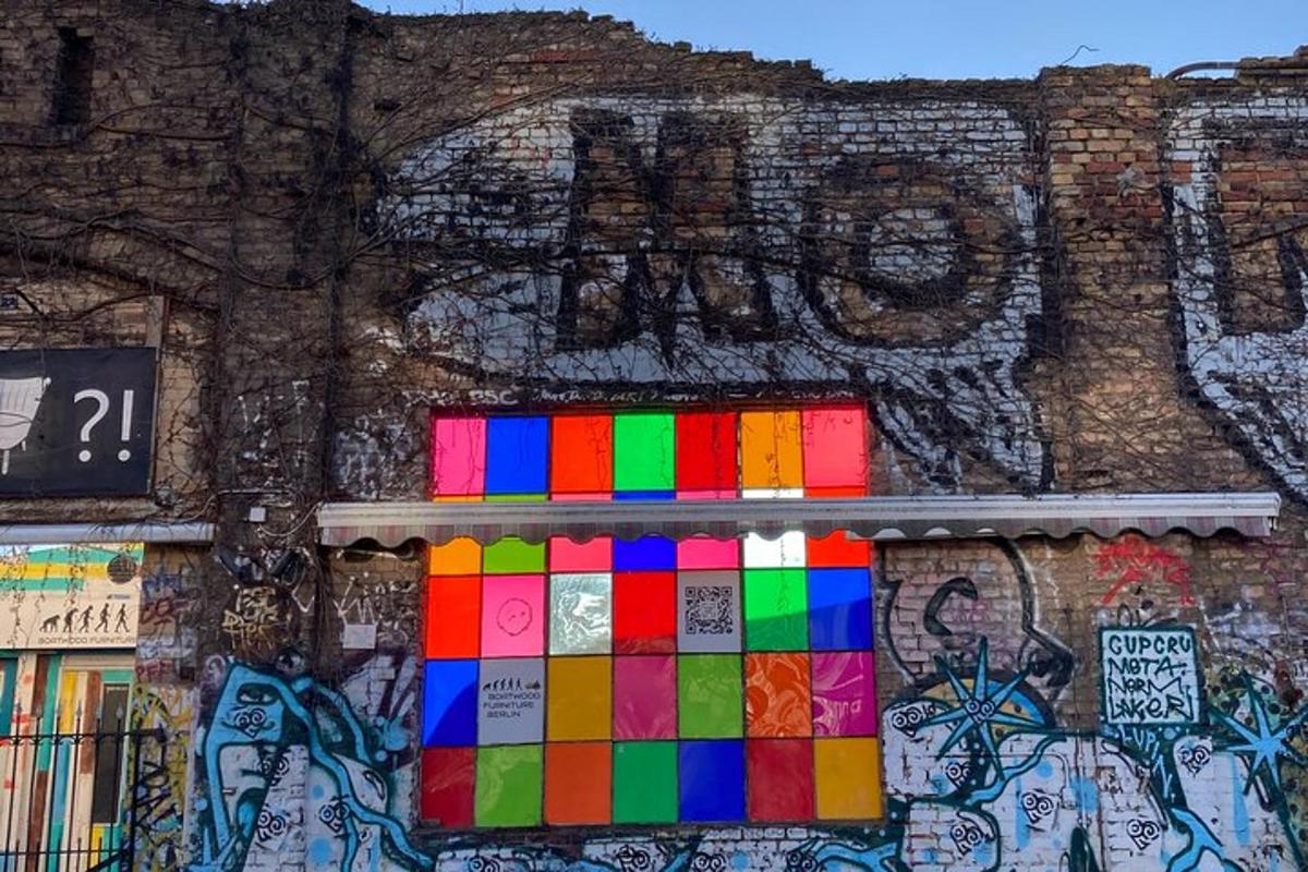 un edificio con un muro coperto di graffiti con una finestra colorata