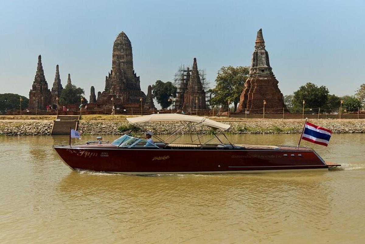 ein Boot mit einem Sonnenschirm auf dem Wasser vor einem Tempel