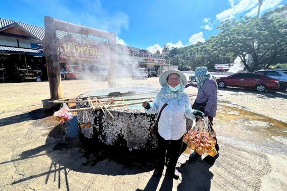 Dos personas paradas frente a una fuente de agua.