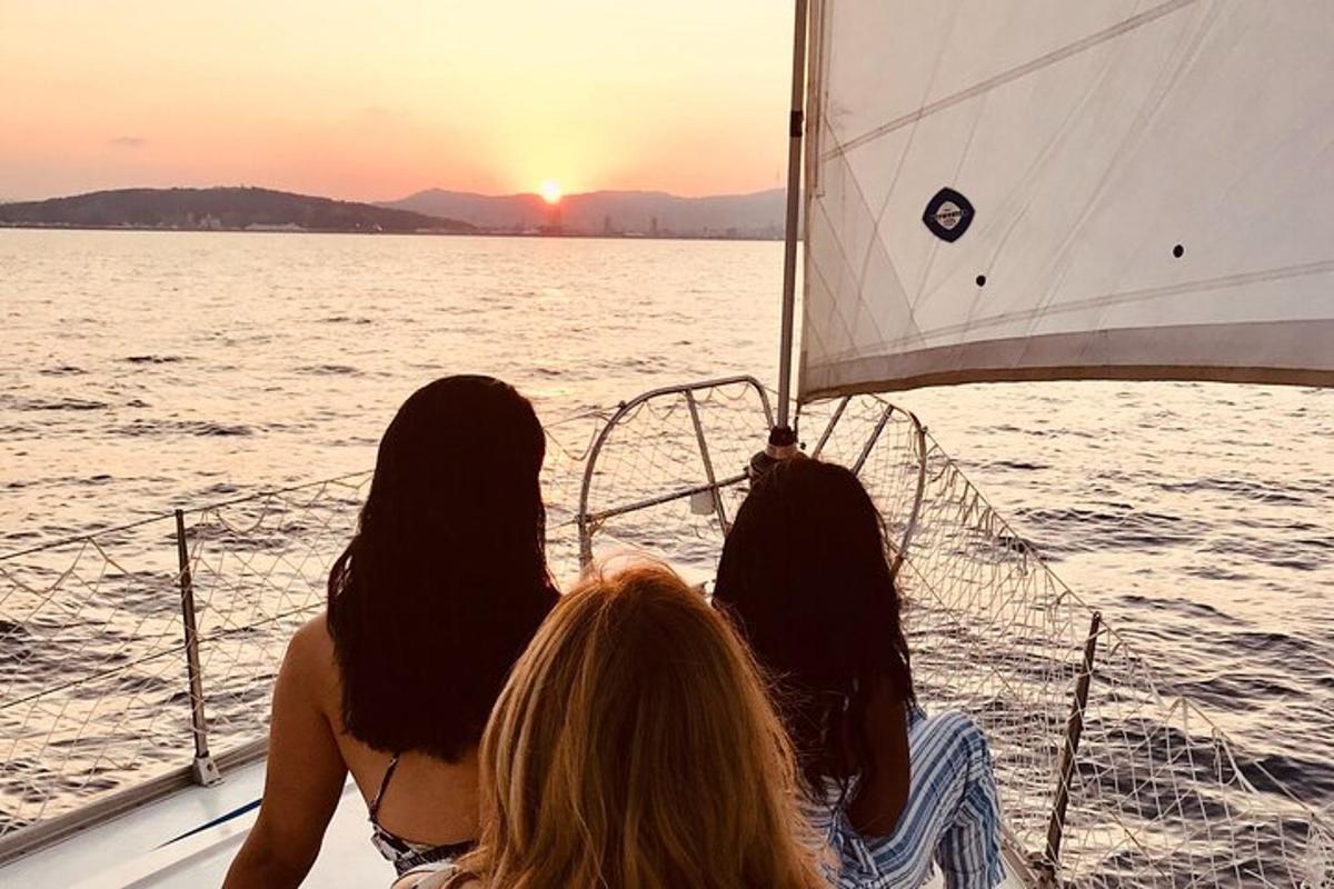 Τρεις γυναίκες κάθονται σε μια βάρκα παρακολουθώντας το ηλιοβασίλεμα