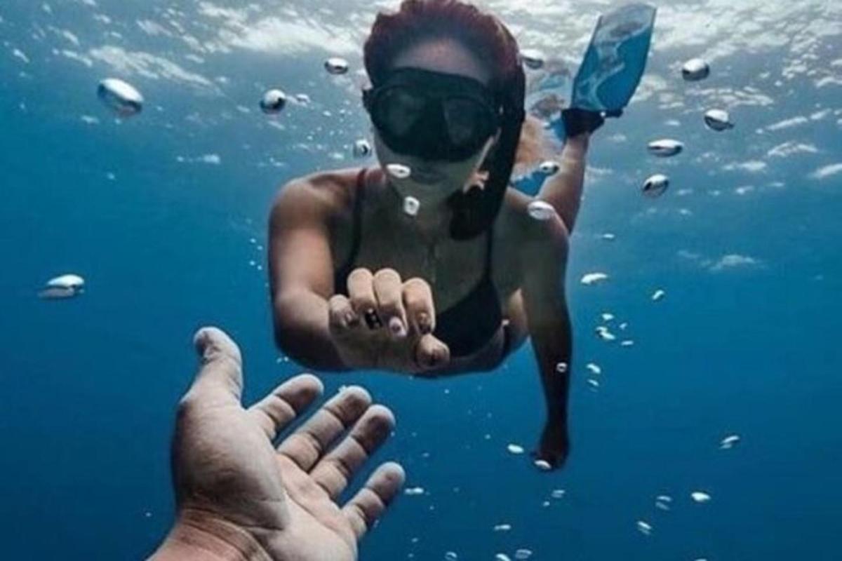 una persona in acqua con una mano nell'acqua