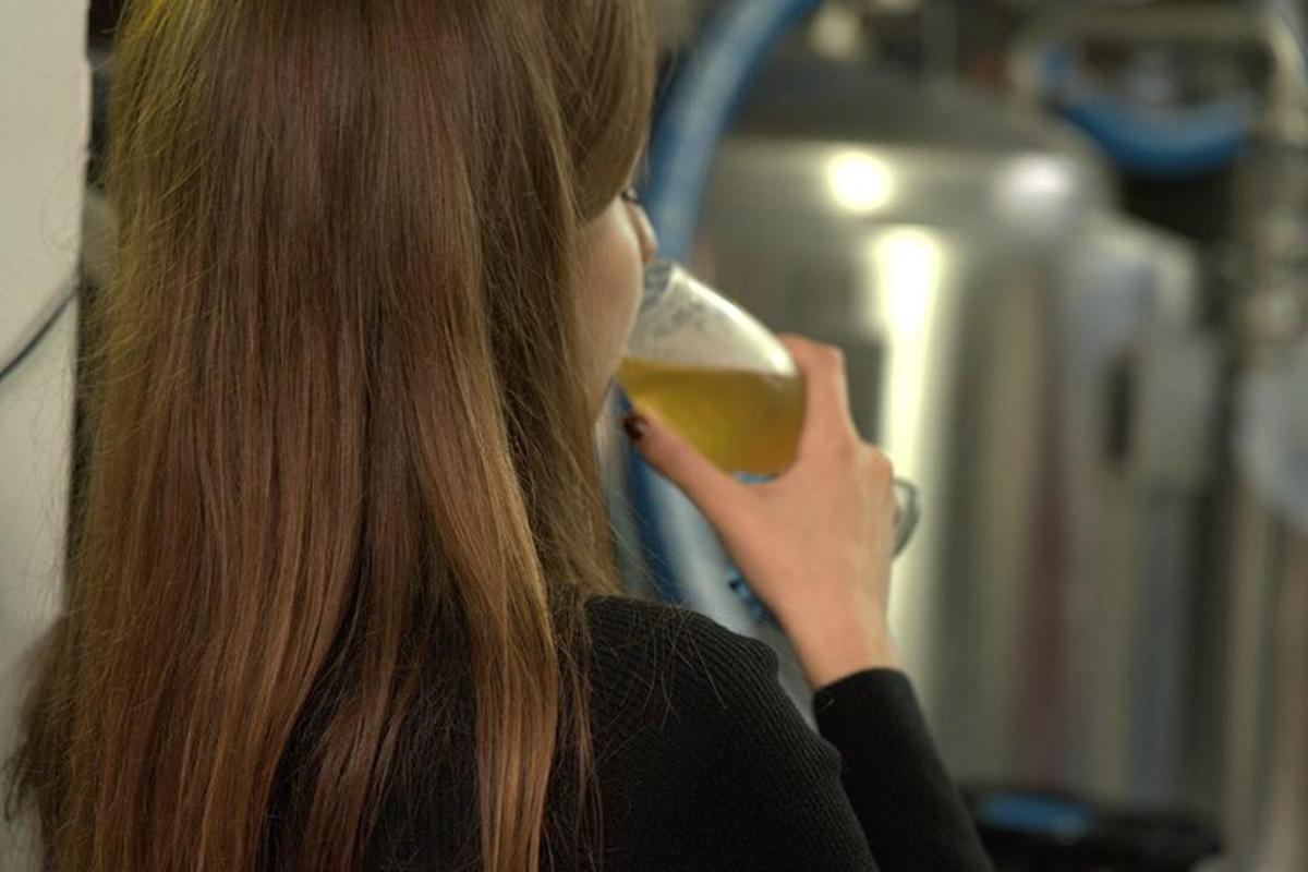 eine Frau trinkt ein Glas Wein