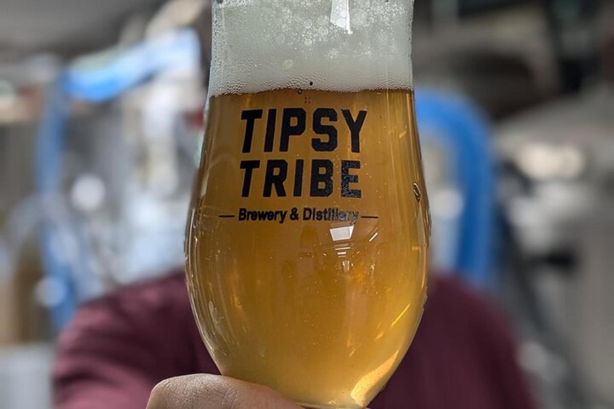 una persona tiene in mano un bicchiere di birra