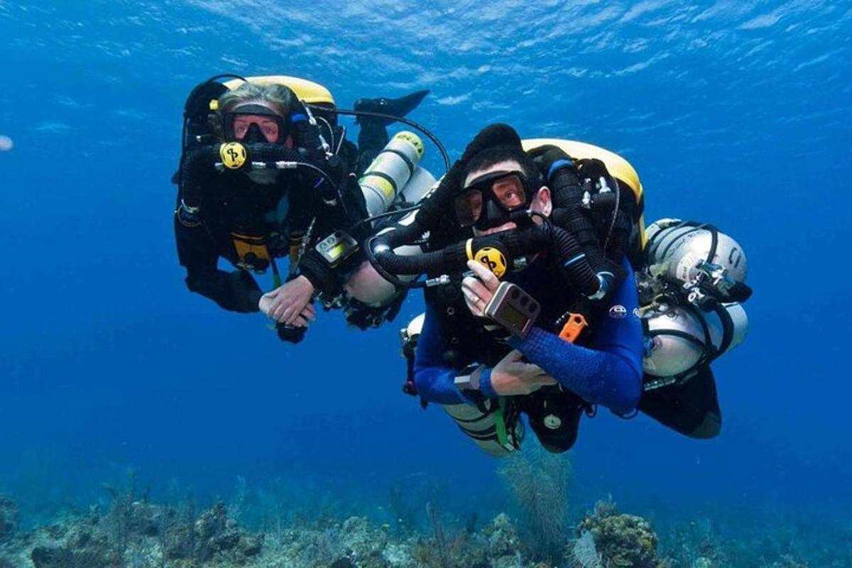 dve osebi v potapljaški opremi plavata v oceanu