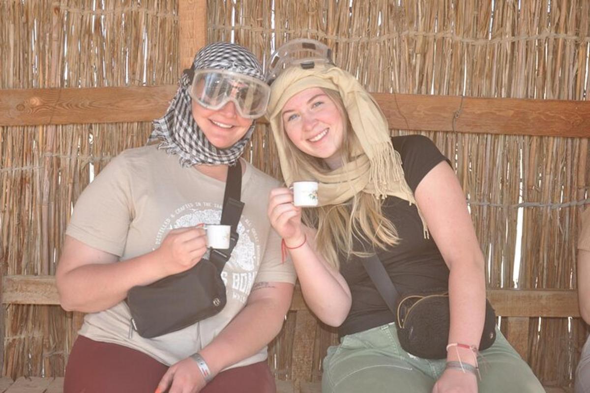 due donne sorridono mentre tengono in mano delle tazze di caffè