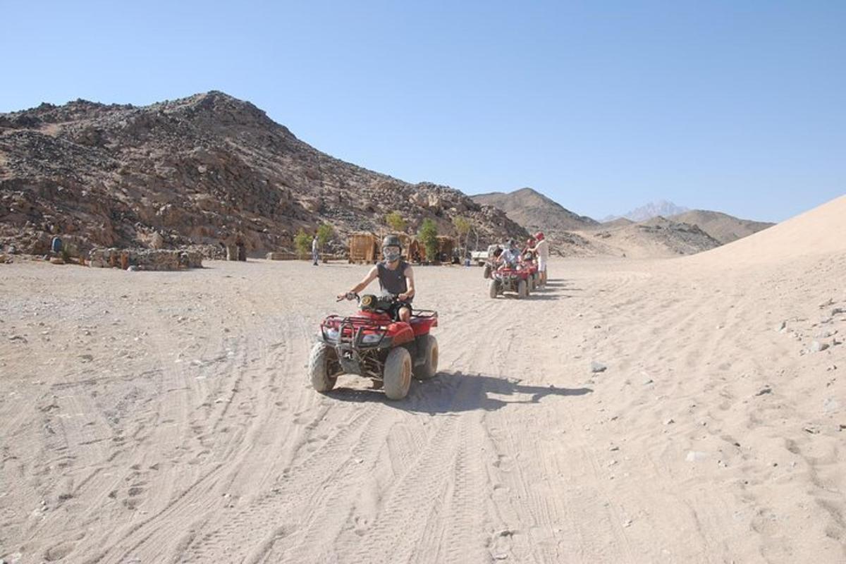 un gruppo di persone che guidano quad nel deserto