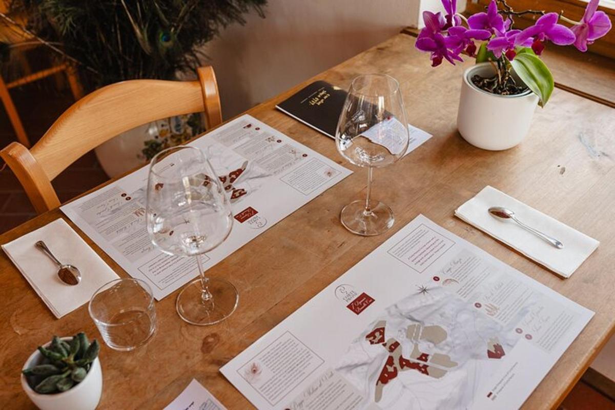 uma mesa de madeira com taças de vinho e papéis sobre ela