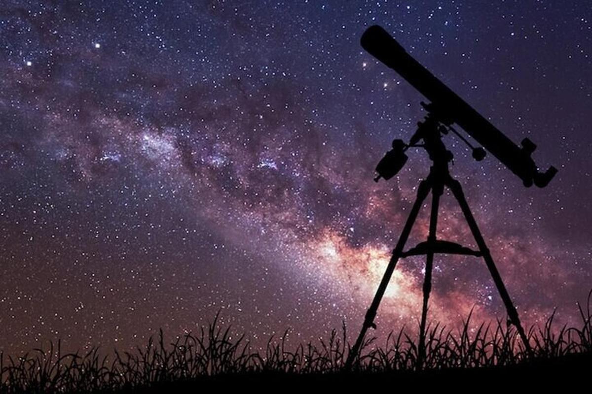 un telescopio su un treppiede che guarda le stelle