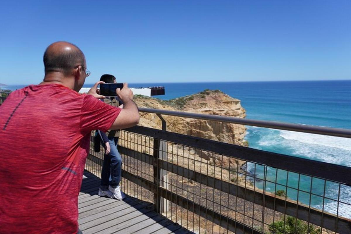 a man taking a picture of the ocean with a camera