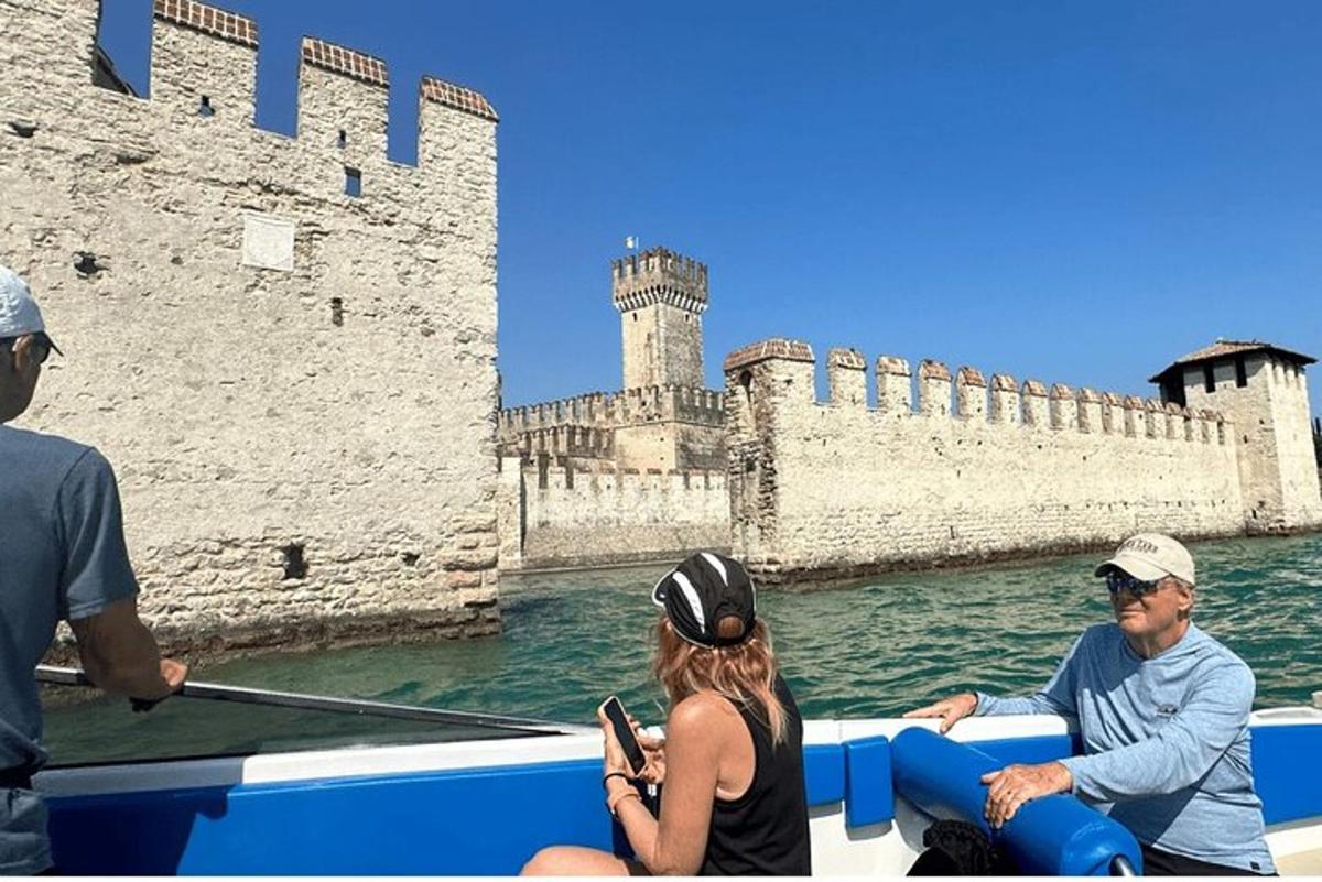 skupina lidí na lodi před hradem