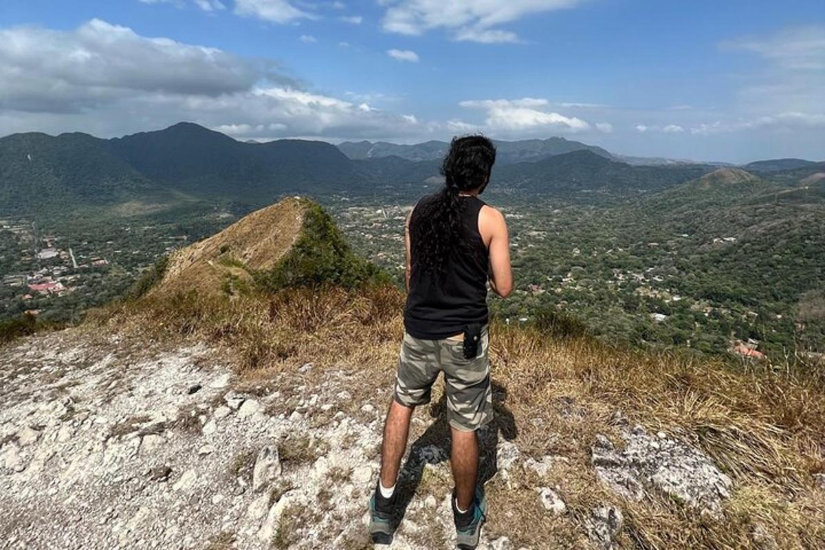 a man standing on top of a mountain overlooking a city