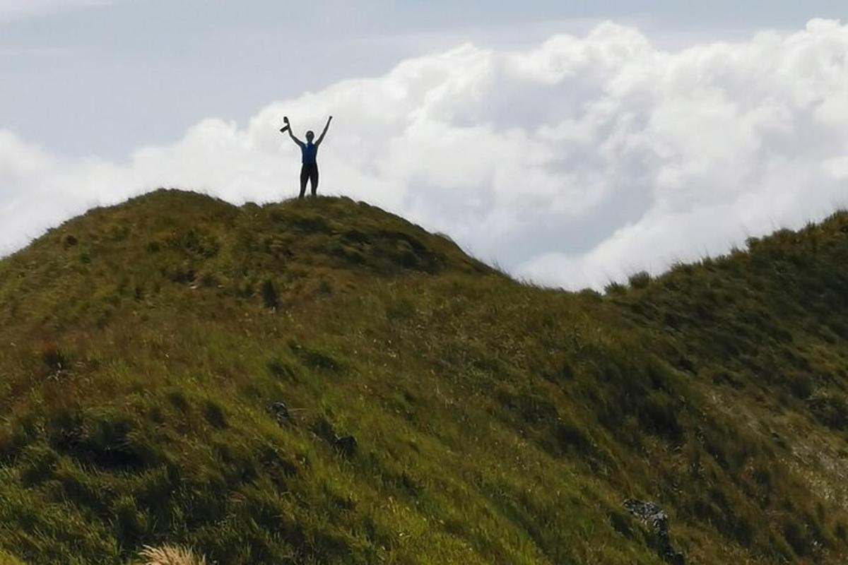 a man standing on top of a grassy hill