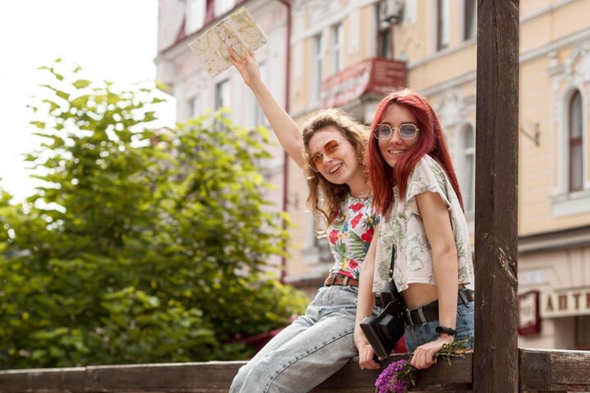 dvě dívky sedící na plotě a držící ceduli