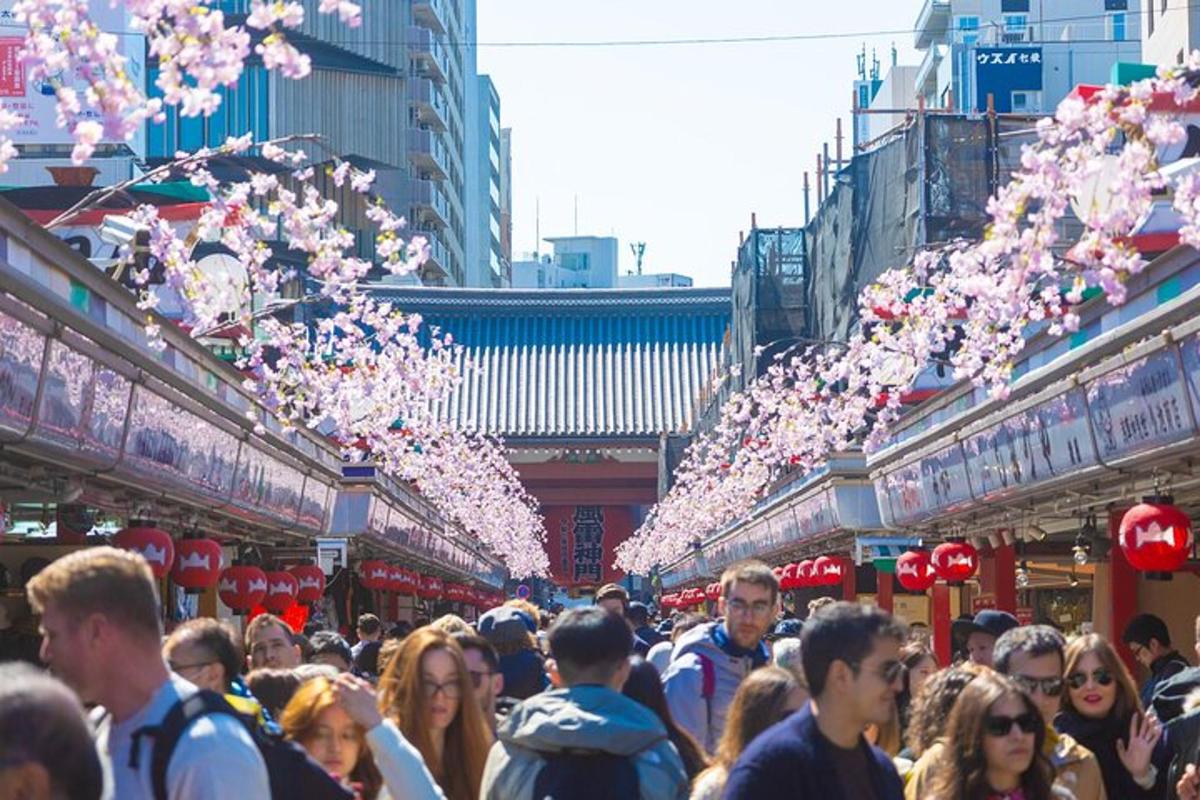a crowd of people walking through a market with trees