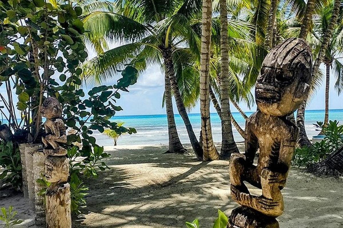 a couple of statues on a beach with palm trees