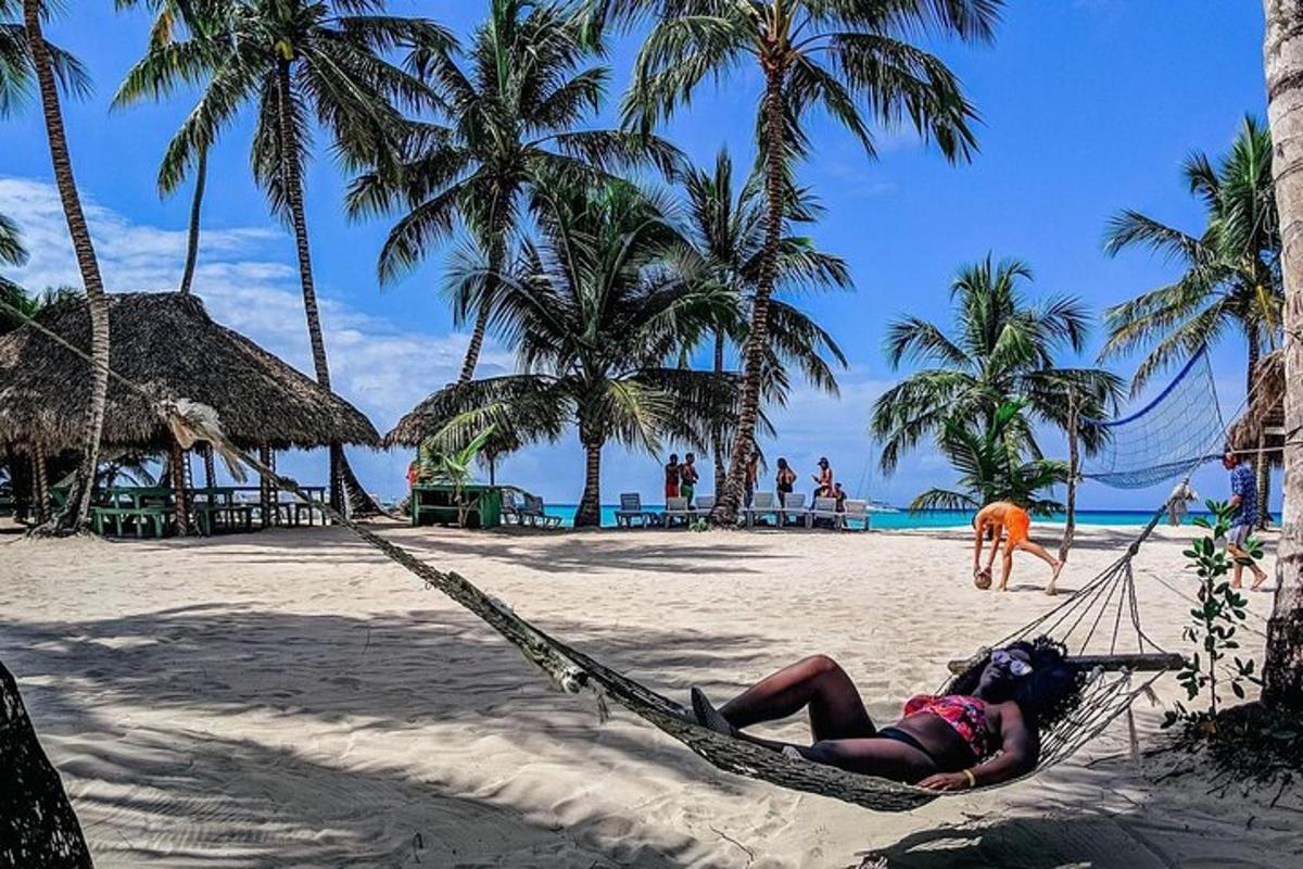 a woman laying in a hammock on a beach