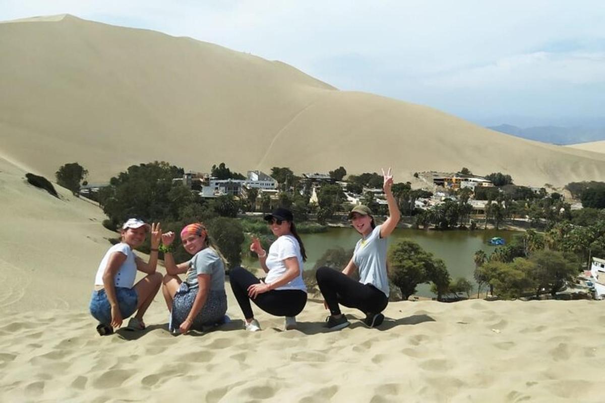 Un grupo de personas sentadas en una colina de arena