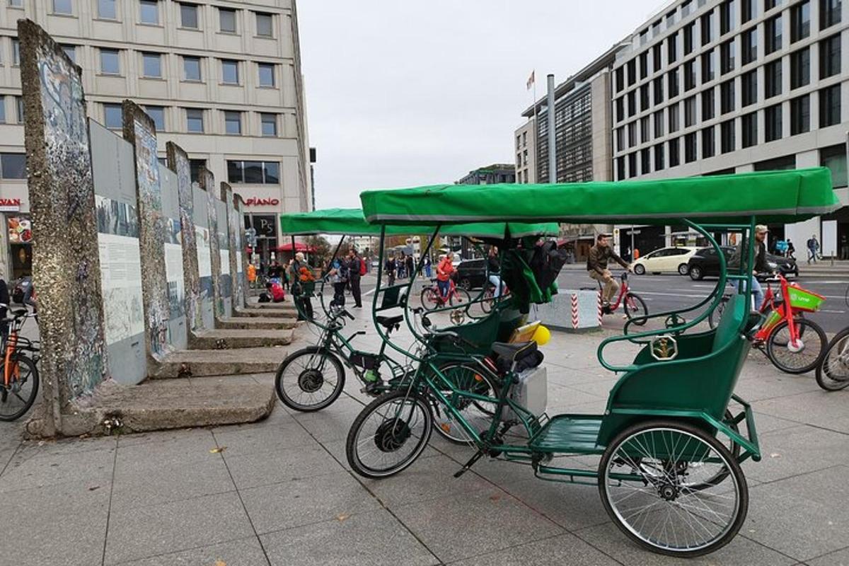 a group of green bikes parked on a sidewalk