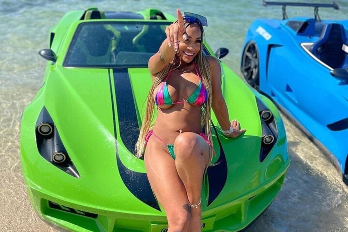 uma mulher de biquíni sentada em um carro verde