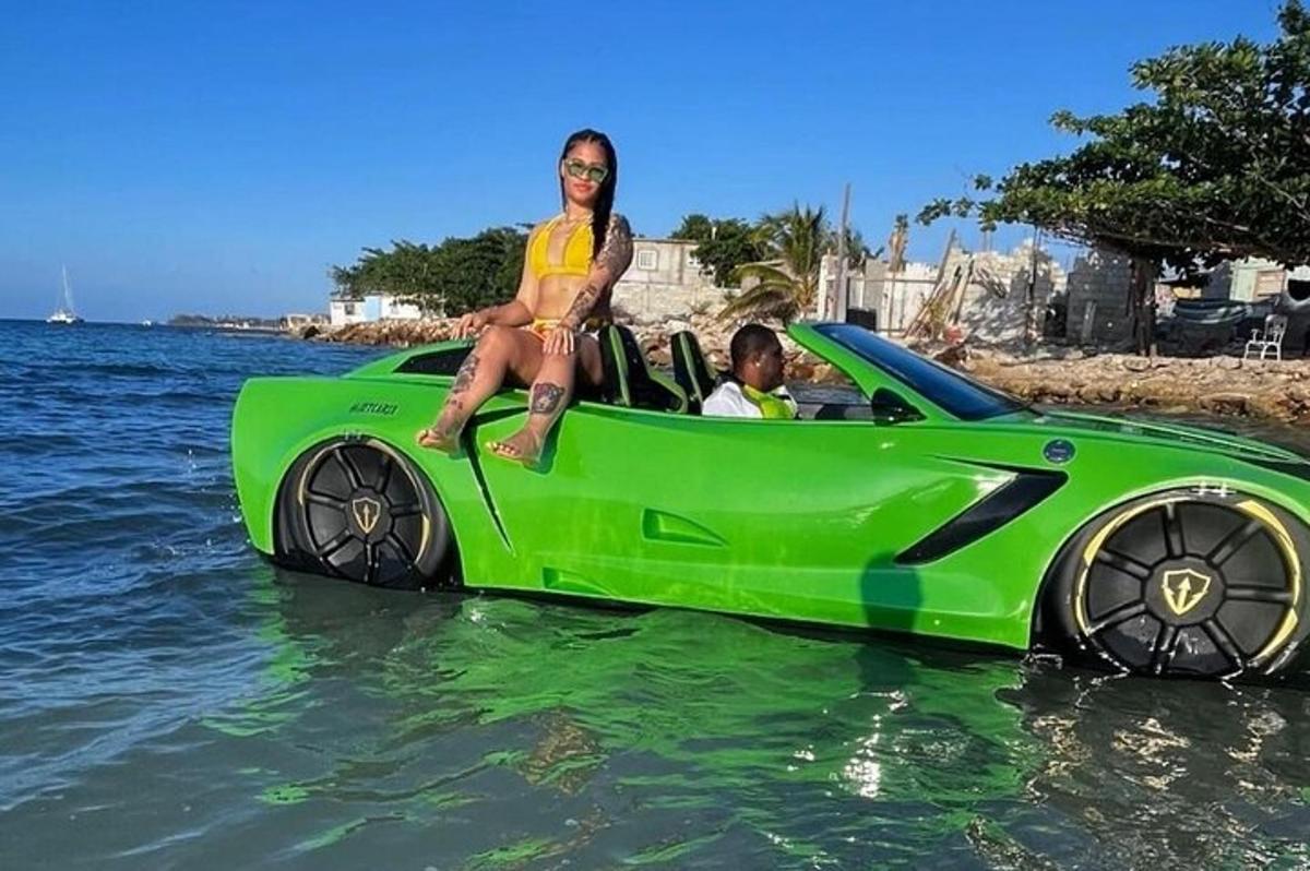 uma mulher sentada em um carro verde na água